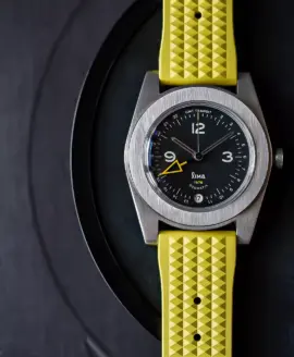Yellow waffle style rubber strap on a black dial watch with yellow GMT hand